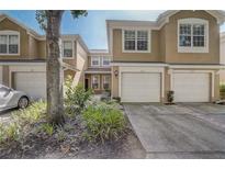 Inviting townhome exterior with a one-car garage and well-maintained landscaping in a friendly community at 2763 Metro Sevilla Dr # 103, Orlando, FL 32835