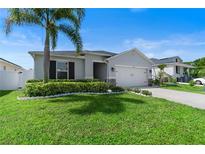 Charming single-story home featuring a well-manicured lawn and a two-car garage at 4564 Orchard Grove Rd, St Cloud, FL 34772