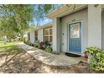 Charming single-story home with a blue front door, well-manicured landscaping, and a welcoming walkway at 608 Swanson St, Groveland, FL 34736