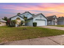Charming single-Gathering home featuring a well-maintained lawn and attached two-car garage at 9355 Telfer Run, Orlando, FL 32817