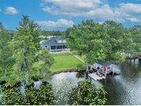 Stunning lakefront home featuring a boat house, lush landscaping, and a private swimming pool at 339 Carolyn Dr, Oviedo, FL 32765