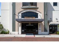 Elegant building entrance featuring detailed stonework, glass doors, and a welcoming design at 111 E Monument Ave # 801, Kissimmee, FL 34741
