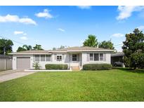 Charming single-story home with manicured lawn, attached garage, and inviting front entrance under a bright sky at 1322 Morris Ave, Orlando, FL 32803