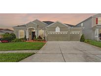 Charming single-story home with a well-manicured lawn and three-car garage at 13478 Summer Rain Dr, Orlando, FL 32828