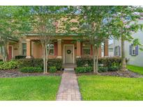 Charming home exterior with manicured landscaping, walkway, and blooming trees at 14897 Evergreen Oak Loop, Winter Garden, FL 34787