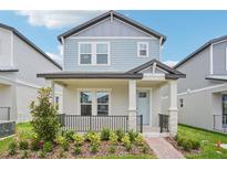 Charming two-story home featuring a welcoming front porch and neat landscaping at 16526 Silver Brook Way, Winter Garden, FL 34787