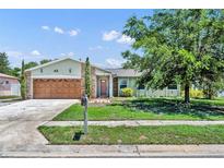 Charming single-story home with a lush front yard, stone accents, and a spacious two-car garage at 1930 Aster Dr, Winter Park, FL 32792