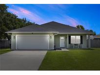 Charming single Gathering home with a two-car garage, well-manicured lawn, and covered entryway at 2305 Ascot Ave, Orlando, FL 32833