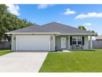 Charming single-story home with a manicured lawn, attached garage, and inviting front porch at 2305 Ascot Ave, Orlando, FL 32833