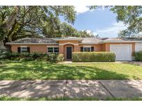Charming single-story home features a lush green lawn and mature landscaping, creating inviting curb appeal at 3141 Cashmere Dr, Orlando, FL 32827