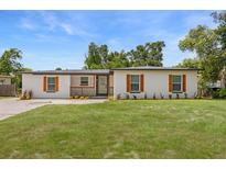 Charming single-story home with white exterior, front lawn, and a welcoming front porch at 4714 Abaca St, Orlando, FL 32808