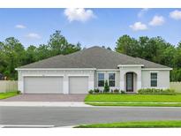 Charming single-story home featuring a three-car garage and manicured lawn at 5204 Obsidian Gate Dr, Mount Dora, FL 32757