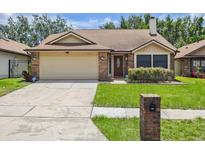 Charming one-story brick home with a well-manicured lawn and a two-car garage at 7263 Spring Villas Cir, Orlando, FL 32819