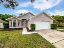 Charming single-story home featuring a well-maintained lawn and a two-car garage at 8994 Fort Jefferson Blvd, Orlando, FL 32822