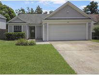 Charming single-story home featuring a two-car garage, manicured lawn, and welcoming curb appeal at 1026 Mccully Ct, Oviedo, FL 32765