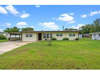 Charming single-story home with a well-maintained lawn and an attached carport on a sunny day at 110 N Sunland Dr, Sanford, FL 32773