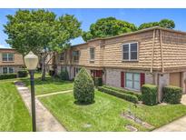 Inviting townhome with manicured lawn, mature trees, and brick and siding exterior at 200 St Andrews Blvd # 911, Winter Park, FL 32792