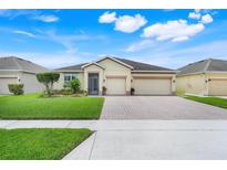 Charming single-story home with well-manicured lawn, brick driveway, and two-car garage, perfect for suburban living at 3504 Cayugas Loop, St Cloud, FL 34772