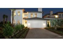 Striking modern home exterior with manicured landscaping, a brick driveway, and a three-car garage at 4007 Grande Brick Loop # 13, Orlando, FL 32837