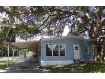Charming single-story home with a covered parking area and mature tree providing shade at 41 Sunset Cir, Lake Alfred, FL 33850