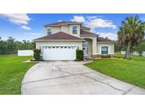 Charming two-story home with a well-manicured lawn and a spacious driveway at 412 Mallard Way, Kissimmee, FL 34759