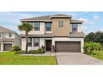 Beautiful two-story home features a well-manicured lawn, neutral color scheme, and attached two-car garage at 4429 Ganesha Loop, Kissimmee, FL 34746