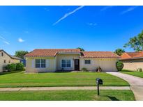 Charming single-story home with a well-manicured lawn and a classic red tile roof on a sunny day at 5654 Minute Man Ct, Orlando, FL 32821