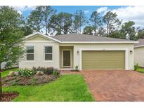 Inviting single-story home featuring brick driveway, one-car garage, and colorful landscaping at 5909 Cliffbow Loop, Leesburg, FL 34748