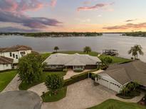 Stunning lakefront home with lush landscaping, mature trees, and private boat dock offering serene water views at 4318 Waterfront Pkwy, Orlando, FL 32806