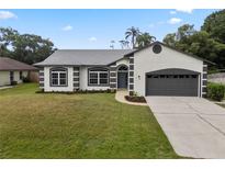 Charming single-Gathering home with well-maintained lawn, gray roof, driveway and two-car garage at 1161 Roxboro Rd, Longwood, FL 32750