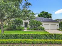 Charming single-story home featuring manicured landscaping, a two-car garage, and a welcoming front yard at 1640 Mayfield Ave, Winter Park, FL 32789