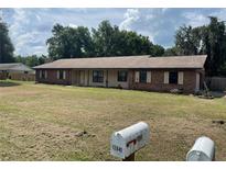 Charming single-story home with a brick exterior, lawn, and inviting curb appeal at 17836 Palm St, Umatilla, FL 32784