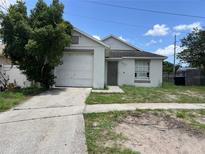 Charming single-Gathering home featuring an attached garage and a simple, inviting front yard at 1809 Elm Ridge Ct, Orlando, FL 32808