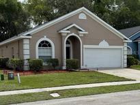 Charming single-story home featuring manicured lawn and attached two car garage at 2131 Kaylas Ct, Orlando, FL 32817