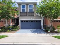 Two-story home with gray painted garage door, balcony, nice landscaping, and a concrete driveway at 2261 Brookridge Trl, Sanford, FL 32773