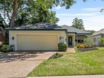 Charming single-story home featuring a well-maintained lawn, mature trees, and an attached two-car garage at 235 S Shadowbay Blvd, Longwood, FL 32779
