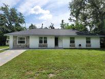 Charming single-story home with white brick facade and well-maintained front lawn at 2417 Yale Ave, Sanford, FL 32771