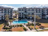 Beautiful pool and common area surrounded by lush landscaping at beachfront condo buildings at 2700 Ocean Shore Blvd # 515, Ormond Beach, FL 32176
