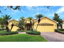 Welcoming single Gathering home boasts a two car garage, well manicured lawn and lush landscaping at 340 Sorrento Rd, Kissimmee, FL 34759