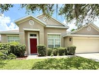 Charming single-story home featuring a red front door and well-maintained landscaping at 3539 Maple Ridge Loop, Kissimmee, FL 34741