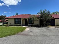 Single-story home features a red tiled roof, light yellow walls, dark trim, and simple landscaping at 436 Hunter Cir, Kissimmee, FL 34758