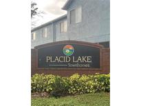Placid Lake Townhomes brick sign with colorful lotus flower logo surrounded by greenery at 454 Wilton Cir, Sanford, FL 32773