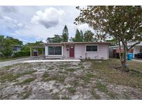 Charming single-story home with a red front door, carport, and partially xeriscaped front yard at 535 Romano Ave, Orlando, FL 32807