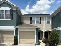 Charming townhome featuring a one-car garage and inviting facade with lush landscaping at 650 Shropshire Loop, Sanford, FL 32771