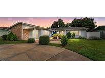Charming single-story home showcasing a well-manicured front yard with brick and light-blue accents at 830 Hawkes Ave, Orlando, FL 32809