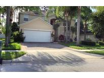 Charming two-story home boasts a paved driveway, attached garage, and mature palm tree landscaping in a desirable location at 1130 Burland Cir, Winter Garden, FL 34787