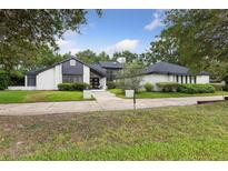 Charming white-brick home with modern black trim and well-manicured landscaping creates an inviting curb appeal at 1795 Markham Glen Cir, Longwood, FL 32779