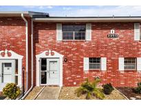 Charming brick condo featuring white trim, bright natural light, and well-maintained landscaping at 2250 S Palmetto Ave # I-11, Daytona Beach, FL 32119