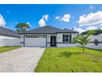 Beautiful home with a manicured lawn and a driveway leading to an attached two car garage at 3507 W Jefferson St, Orlando, FL 32805