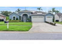 Charming blue home featuring a well-manicured lawn, two-car garage, and freshly painted driveway at 4110 Maplegrove Dr, Orlando, FL 32818